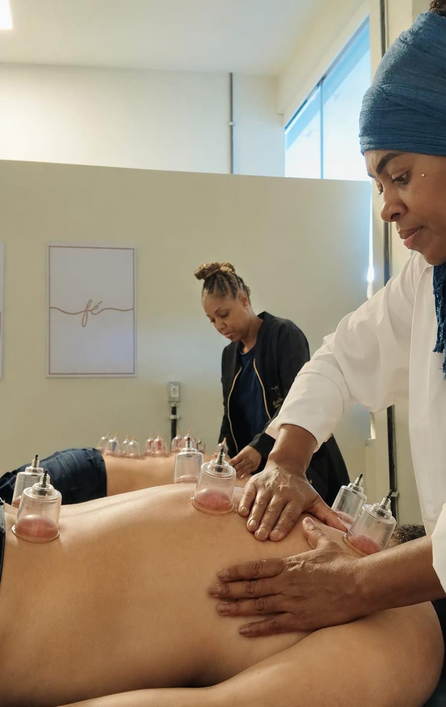 Aurélia e Kelly realizando massagem com ventosas durante um atendimento